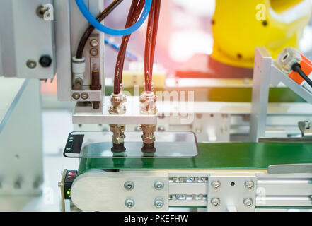 Schermata di robotica la pellicola di protezione o di copertura in vetro nella fabbricazione di fabbrica del telefono Foto Stock