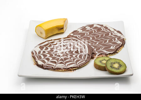 Crêpe al cioccolato, cioccolato pancake con banana e kiwi isolati su sfondo bianco, percorso di clipping incluso Foto Stock