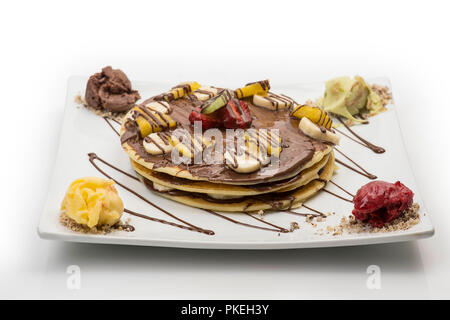 Crêpe al cioccolato con fragole e banane e gelato isolato su bianco, percorso di clipping incluso Foto Stock