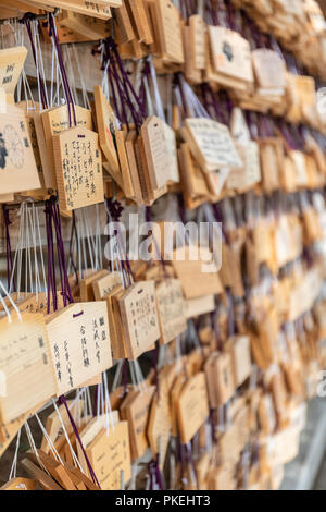 Righe di tavolette votive con auguri scritto da visitatori del Tempio di Meiji in Tokyo. Foto Stock