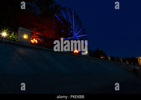 Ruota panoramica sulle rive del fiume Amur a Khabarovsk contro il cielo di notte. Un brillante illuminazione. Fotografato a lunga esposizione. Foto Stock