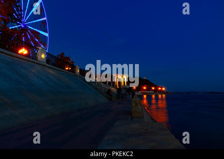 Ruota panoramica sulle rive del fiume Amur a Khabarovsk contro il cielo di notte. Un brillante illuminazione. Fotografato a lunga esposizione. Foto Stock