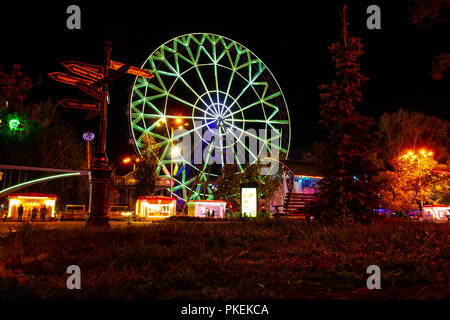 Ruota panoramica sulle rive del fiume Amur a Khabarovsk contro il cielo di notte. Un brillante illuminazione. Fotografato a lunga esposizione. Foto Stock