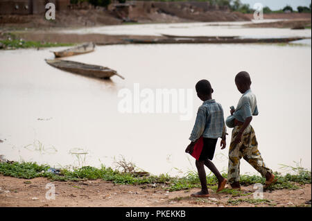 Mali, Africa - circa agosto 2009 - Due nero gli amici africani a piedi attorno a un fiume sporco. Djenne Foto Stock