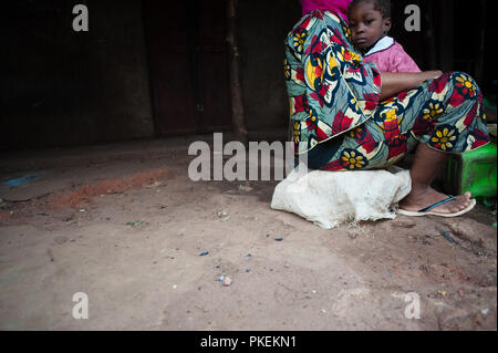 Mali, Africa - circa agosto 2009 - africano nero triste ragazzo protetto dall'abbraccio della sua mamma nel villaggio rurale vicino a Bamako. Foto Stock