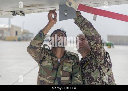 KABUL, Afghanistan (25 luglio 2018) - 1Lt. Zubaide, Afghan Air Force A-29 manutentore, spiega il funzionamento della macchina di pistola pannello di riarmare durante il corso di formazione Luglio 22, 2018, Kabul Air Wing, Afghanistan. Zubaide è una parte della prima squadra A-29 istruttori di manutenzione essendo certificata per insegnare in Afghanistan. Foto Stock