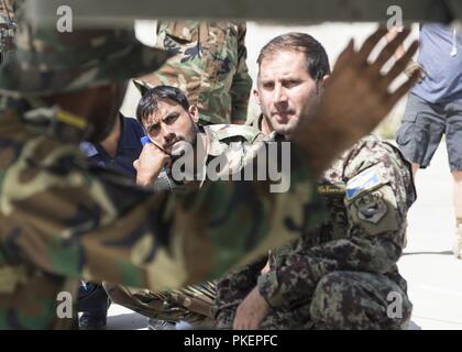 KABUL, Afghanistan (25 luglio 2018) - Un Afghan aviatori ascolta attentamente come un A-29 armi istruttore spiega le funzionalità di un-29 bomba rack espulsore Luglio 25, 2018, Kabul Air Wing, Afghanistan. L'istruttore è uno dei tre afghani che verrà certificato per insegnare in treno, consigliare e assistere i consulenti Command-Air. Foto Stock