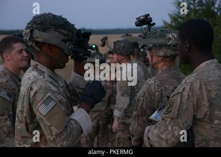 Stati Uniti Paracadutisti assegnato al 2° Battaglione, 503rd Reggimento di Fanteria, 173rd Airborne Brigade preparare per imbracatura procedure di carico con un CH-47F elicottero Chinook assegnato al Bravo Company, 1° Battaglione, 214th reggimento di aviazione, XII Combattere la Brigata Aerea al settimo Esercito di formazione del comando di Grafenwoehr Area Formazione, Germania, 27 luglio 2018. Foto Stock