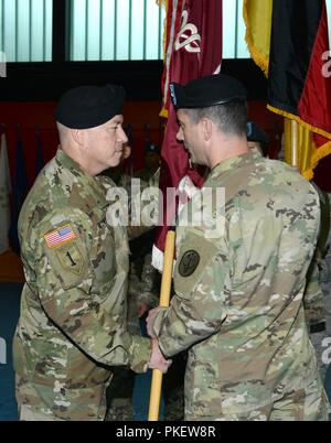 Stati Uniti Esercito Col. Timothy L. Hudson (a destra), comandante di Landstuhl Regional Medical Center, passa il LRMC colori per il comando in arrivo sergente maggiore, il comando Sgt. Il Mag. Thurman L. Reynolds durante la sua assunzione di responsabilità cerimonia tenutasi il 1 agosto, 2018 a Landstuhl/Germania Foto Stock