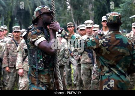 Stati Uniti I soldati dell esercito ricevere istruzioni sulla corda swing ostacolo alla guerra nella giungla, scuola Achiase Base Militare, Akim Achiase, Ghana, 1 agosto 2018. La Guerra nella Giungla Scuola è una serie di situazionale esercizi di formazione progettate per formare i partecipanti in counter-insorgenza interna e delle operazioni di protezione. Foto Stock