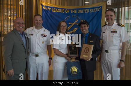 SEATTLE (Agosto 1, 2018) Seattle Navy League Presidente Jeff Davis presenta una placca di apprezzamento per la Cmdr. Elaine Brunelle, comandante della guidato-missile destroyer USS Momsen (DDG 92), per partecipare alla sessantanovesima Seafair annuale Settimana della flotta durante la Seattle Navy League Cena di benvenuto presso il World Trade Center nel centro di Seattle. Seafair Settimana della flotta è una celebrazione annuale del mare servizi in cui i marinai, Marines e Guardia Costiera di membri da visitare U.S. La marina e la Guardia costiera navi e navi da Canada rendono la città una porta di chiamata. Foto Stock