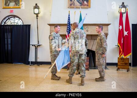 FORT BENNING, Ga. (Agosto 3, 2018) - Il Mag. Gen. Gary M. Brito, centro, la manovra di centro di eccellenza, mani U.S. La fanteria dell'esercito colori della scuola di Brig. Gen. David M. Hodne, sinistra, il nuovo comandante della scuola di fanteria. Il MCoE terrà un cambiamento della responsabilità per la scuola di fanteria 3 Agosto a Benning Club a Fort Benning, Georgia, accogliente Hodne. Col. Townley R. Hedrick, destra, che ha servito come il comandante della scuola di fanteria dal maggio, è stare su come il sostituto del Comandante. Foto Stock