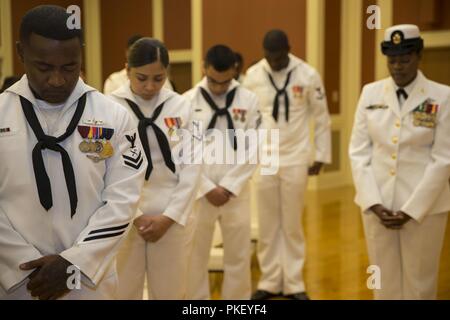 I marinai bow le loro teste durante l invocazione al Naval Medical Center di Camp Lejeune modifica del comando presso il Padiglione Marston in Marine Corps base Camp Lejeune, N.C., 2 agosto 2018. La modifica del comando formalmente trasferita autorità e responsabilità di NMCCL da Capt. James L. Hancock al cap. Jeffrey W. Timby. Foto Stock