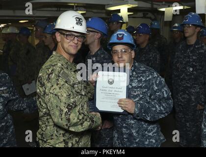 NEWPORT NEWS, Va. (Agosto 2, 2018) Danni Controlman 2a classe Alessandro Chicarella, dal Nord Providence, Rhode Island, assegnato alla USS Gerald Ford (CVN 78) Engineering Department, riceve una buona condotta medaglia certificato dal Lt. La Cmdr. Michael Kniccurbocker, Ford ausiliari officer, durante una cerimonia di premiazione su Ford. Foto Stock