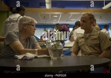 SEATTLE (Agosto 3, 2018) U.S Marine Corps primo tenente Samuel banche parla con un veterano al veterano degli affari del Puget Sound Health Care System durante la flotta Seafair Settimana in Seattle. Seafair Settimana della flotta è una celebrazione annuale del mare servizi in cui i marinai, Marines e Guardia Costiera di membri da visitare U.S. La marina e la Guardia costiera navi e navi da Canada rendono la città una porta di chiamata. Foto Stock