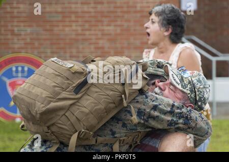 Stati Uniti Marine Corps Sgt. Cory Marshall con la ventiseiesima Marine Expeditionary Unit avvolge il suo padre a Camp Lejeune, N.C., e il Agosto 4, 2018. Marines con la ventiseiesima MEU sono tornati a casa da sei mesi di deployment in mare per gli Stati Uniti Centrale, Africa e Comando europeo aree di funzionamento. Foto Stock