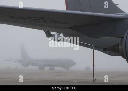 Stati Uniti Air National Guard avieri con il 121 Air Refuelling Wing, Ohio lavorare su KC-135 Stratotankers nella fitta nebbia sul Rickenbacker Air National Guard Base, Ohio Agosto 3, 2018. Avieri rimasti visibili durante le intemperie da indossare i loro nastri riflettenti. Foto Stock