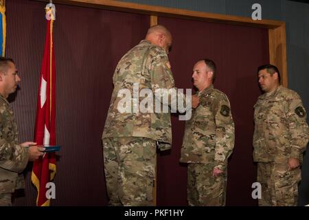 Il maggiore generale Michael Thompson, Aiutante Generale per Oklahoma, perni una medaglia su Master Sgt. Casey Ray, 285th Special Operations Intelligence Squadron (SOI) intelligence analyst, come Master Sgt. Adam Hinsperger, 285th SOIS intelligence analyst, attende di ricevere il suo premio durante la cerimonia del premio il Agosto 4, 2018 a Will Rogers Air National Guard Base, Oklahoma City. I due SOIS aviatori erano ciascuno assegnato il Oklahoma Star valorosi per le loro azioni per salvare un uomo da appendere dopo che essi entrarono nella scena dell'emergenza, mentre fuori la mountain bike in Oklahoma City nel febbraio 19, 2018. Foto Stock