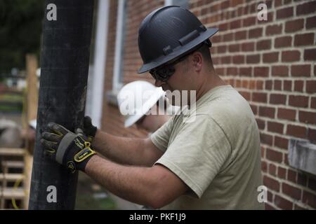 Il personale Sgt. Jack Simonds, un pompiere assegnato a 124Ingegnere Civile Squadron, Campo Gowen Boise, Idaho, assiste con la colata di cemento parete dello stelo in West Virginia scuole per i sordi e ciechi, Romney, W. Va., 31 luglio 2018. Avieri da 124CES ha viaggiato per la scuola per un innovativo disponibilità alla formazione che i benefici della scuola e offre corsi di formazione per i membri del servizio. Foto Stock