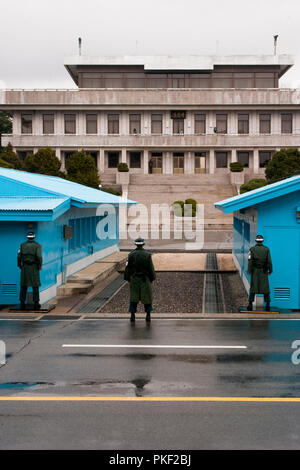 Tre sud coreano soldati che proteggevano la zona demilitarizzata come un nord coreano soldato fa lo stesso. Il personale militare a DMZ sulla penna in coreano Foto Stock