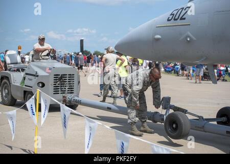 Stati Uniti Air Force Tech. Sgt. Andrew Bergin, un capo equipaggio con la 128Air Refuelling ala in Milwaukee, E DEGLI STATI UNITI Air Force Master Sgt. Adam Olena, un capo equipaggio con il 128th, attaccare una barra di traino per un'F/A-18 Hornet Luglio 28, 2018 a EAA AirVenture in Oshkosh, Wisconsin. L'F/A-18 è stato uno dei circa 30 Dipartimento della Difesa aeromobili a CEA. Foto Stock