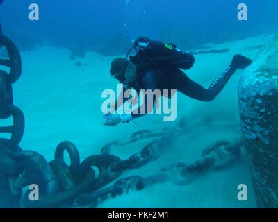 Stati Uniti Navy Builder 2a classe David Perryman, un Seabee con costruzione di immersioni subacquee distacco Charlie (CDDC) da costruzione subacquea Team 2, misure catena di ormeggio nei pressi di Wake Island il 26 luglio 2018. CDDC completato le riparazioni emergenti a Wake Island off-shore di sistema di erogazione del carburante dopo mareggiate scollegato uno della flotta boe di ormeggio. CDDC è il primo arresto del loro sei mesi di schieramento dove stanno realizzando attività di costruzione, ispezione, riparazione e manutenzione di zone costiere oceaniche e strutture a sostegno dell'U.S. 7a flotta. Foto Stock