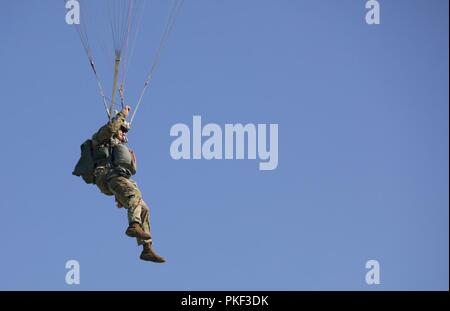 Un U.S. Paracadutista esercito scende con la sua MC-6 paracadute sul Castello zona di caduta durante Leapfest 2018 a West Kingston, RI., 5 agosto 2018. Leapfest è il più grande e il più lungo in piedi, international static line parachute evento di formazione e competizione ospitata dalla 56th squadrone comando, Rhode Island esercito Guardia Nazionale per promuovere tecniche di alto livello e formazione esprit de corps entro il International Airborne comunità. Foto Stock