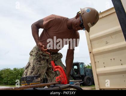 Utilitiesman 2a classe Rashaad McKenzie, da San Pietroburgo, Florida, assegnato alla Naval Mobile Battaglione di costruzione (NMCB) 11, DET. Tagli di Guam un tubo di rame durante la costruzione di una toilette e doccia a Polaris Point, Base Navale Guam, 7 agosto 2018. NMCB-11 fornisce expeditionary e costruzione di capacità ingegneristiche che include la manutenzione e il funzionamento delle basi expeditionary e strutture, tattiche di supporto bridging, assistenza umanitaria attraverso la costruzione di azione civica dettagli e azione civica squadre e il teatro di emergenza le funzionalità di risposta negli Stati Uniti 7F Foto Stock