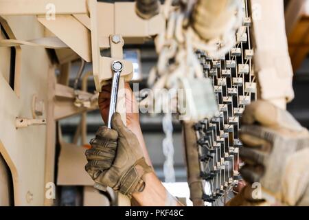 Provincia di Kandahar, Afghanistan (Agosto 2, 2018) -- Un U.S. Soldato dell'esercito assegnato alla società di Golf, 1° Battaglione, dodicesimo Reggimento di Fanteria, seconda della brigata di fanteria combattere la squadra, 4a divisione di fanteria, riparare la porta del veicolo militare, e il Agosto 2, 2018, presso la società del motore area piscina a Kandahar Airfield, Afghanistan. I soldati della società G, forniscono il veicolo e le attrezzature di manutenzione, riparazione e assistenza di recupero per gli Stati Uniti e la NATO i membri del servizio sul campo d'aviazione. Foto Stock