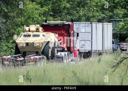 Trattore Semi-rimorchi caricati con attrezzature militari sono schierati il Agosto 1, 2018 su una strada a sud di Post in attesa di essere scaricati a Fort McCoy, Wis. attrezzature è stata spedita in per uso nella formazione 86a Divisione di combattere la formazione per il supporto di esercizio (CSTX) 86-18-02. Migliaia di truppe partecipare all'esercizio e centinaia di pezzi di equipaggiamento sono stati consegnati per quelle truppe per l'uso. Questa è la seconda CSTX ospitato dal 86º nel 2018 e la terza CSTX presso l'installazione di quest'anno. Foto Stock