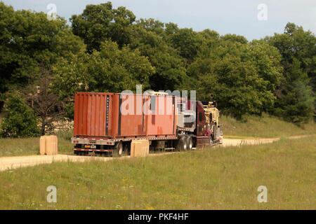 Trattore Semi-rimorchi caricati con attrezzature militari sono schierati il Agosto 1, 2018 su una strada a sud di Post in attesa di essere scaricati a Fort McCoy, Wis. attrezzature è stata spedita in per uso nella formazione 86a Divisione di combattere la formazione per il supporto di esercizio (CSTX) 86-18-02. Migliaia di truppe partecipare all'esercizio e centinaia di pezzi di equipaggiamento sono stati consegnati per quelle truppe per l'uso. Questa è la seconda CSTX ospitato dal 86º nel 2018 e la terza CSTX presso l'installazione di quest'anno. Foto Stock