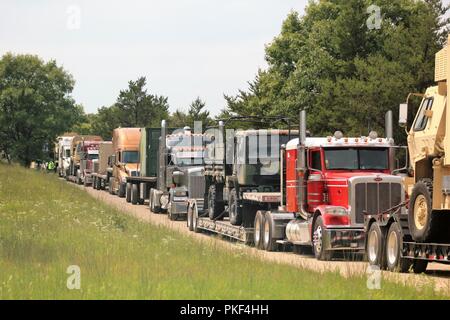 Trattore Semi-rimorchi caricati con attrezzature militari sono schierati il Agosto 1, 2018 su una strada a sud di Post in attesa di essere scaricati a Fort McCoy, Wis. attrezzature è stata spedita in per uso nella formazione 86a Divisione di combattere la formazione per il supporto di esercizio (CSTX) 86-18-02. Migliaia di truppe partecipare all'esercizio e centinaia di pezzi di equipaggiamento sono stati consegnati per quelle truppe per l'uso. Questa è la seconda CSTX ospitato dal 86º nel 2018 e la terza CSTX presso l'installazione di quest'anno. Foto Stock