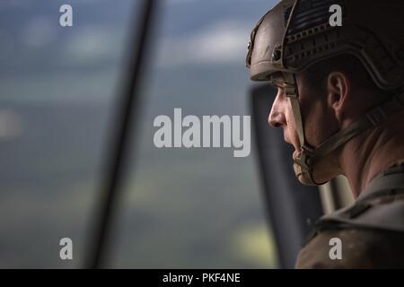 Master Sgt. Craig Stott, 824th Base Defense Squadron jumpmaster, esegue la scansione della zona di caduta al di sotto prima di un static-line saltare da un HC-130J contro il re II, luglio 31, 2018 nei cieli di Georgia del Sud. Il 820th Base Defense gruppo include airborne-qualified aviatori di rafforzare a livello mondiale la sua-forza dispiegabile capacità di protezione e richiede loro di passare periodicamente per mantenere la loro qualifica. Foto Stock