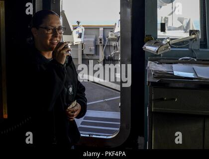 OCEAN (Agosto 7, 2018) della Cmdr. Claudine Caluori, comandante della guidato-missile destroyer USS Sterett (DDG 104), annuncia la nave è di nuovo chief petty officer selectees per l'anno fiscale via 1MC sistema di annuncio. Sterett è in corso negli Stati Uniti La terza area della flotta di operazioni. Foto Stock