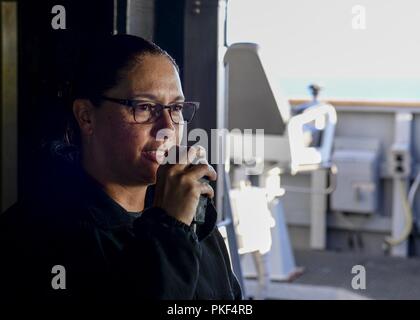 OCEAN (Agosto 7, 2018) della Cmdr. Claudine Caluori, comandante della guidato-missile destroyer USS Sterett (DDG 104), annuncia la nave è di nuovo chief petty officer selectees per l'anno fiscale via 1MC sistema di annuncio. Sterett è in corso negli Stati Uniti La terza area della flotta di operazioni. Foto Stock