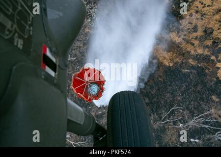 Un UH-60 Blackhawk di 2-25 Reggimento di aviazione, XXV Combattere la Brigata Aerea, rilascia il payload di acqua da un Bambi Bucket oltre un wildfire al Mākua Kea'au riserva forestale 6 Agosto. Gli equipaggi DA PARTE DEGLI STATI UNITI Esercito, il Dipartimento della Terra e delle risorse naturali e la divisione di la silvicoltura e la fauna selvatica i vigili del fuoco hanno lavorato insieme per contenere e spegnere la fiamma. Foto Stock