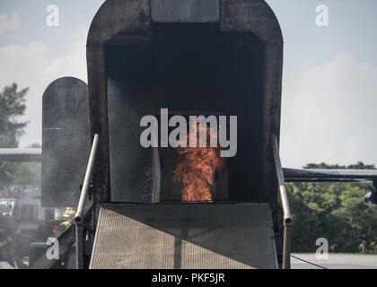 Fire erutta dalla parte posteriore del velivolo formazione giunto durante il live-formazione antincendio Agosto 7th, 2018 a Kadena Air Base, Giappone. L'area di formazione utilizzato per l'esercizio ha un fuoco controllato sistema, utilizzato per simulare la masterizzazione di jet fuel nel caso di un aeromobile di emergenza. Foto Stock