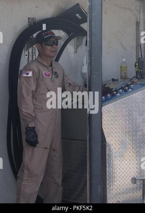 Mitsuo Yamaguchi, xviii ingegnere civile Training Squadron assistant, trigger aeromobile incendio durante la joint live-formazione antincendio Agosto 7th, 2018 a Kadena Air Base, Giappone. L'area di formazione utilizzato per l'esercizio ha un fuoco controllato sistema, utilizzato per simulare la masterizzazione di jet fuel nel caso di un aeromobile di emergenza. Foto Stock