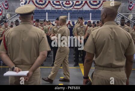 Grandi laghi, Ill. (Agosto 7, 2018) Capt. Erik Thors, comandante del reclutamento di formazione di comando (RTC), centro, parla al RTC chief petty officer selectees e i capi pasticcio nella flotta del Pacifico drill hall in RTC. Sessantotto RTC prima classe sottufficiali sono stati selezionati per il capo. Più di 30.000 reclute graduate annualmente dalla marina è solo di boot camp. Foto Stock