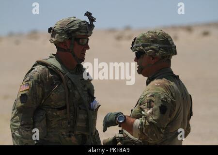 Col. Michael Wegscheider (sinistra), commander, 56th Stryker Brigade Combat Team, ventottesima divisione di fanteria, Pennsylvania Esercito Nazionale Guardia, fornisce un aggiornamento sul tempo di funzionamento al Col. Marc Ferraro (a destra), ventottesima divisione di fanteria posteriore Comandante di stacco, 5 Agosto presso il Centro Nazionale di Allenamento, Fort Irwin, California Foto Stock