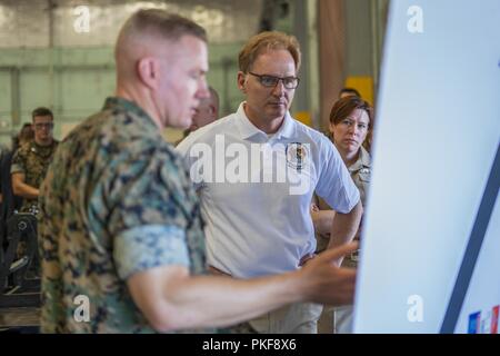 Stati Uniti Marine Lt. Col. Foster Ferguson, 1° Battaglione di manutenzione comandante, spiega il gruppo di risultati del benchmark nel corso dell'ultimo anno fiscale al di sotto segretario della Marina Thomas B. Modly durante un tour su Camp Pendleton, California, e il Agosto 8, 2018. Durante il tour, Modly si è presentato con una vetrina per le unità logistiche e di capacità operative. Foto Stock