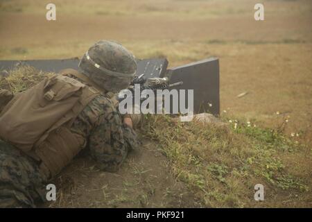 Stati Uniti Lancia Marine Cpl. Caleb Keller, una macchina di fanteria gunner con 3d battaglione, 3d reggimento Marine incendi presso nozionale posizioni nemiche durante l'esercizio Bougainville ho presso la gamma Ulupau Training Facility in Marine Corps base Hawaii, Agosto 9, 2018. Bougainville I è la prima fase del pre-distribuzione del ciclo di formazione per il battaglione, ed è un esercizio focalizzata sulla creazione di piccole unità di abilità per aumentare la competenza in combattimento. Foto Stock