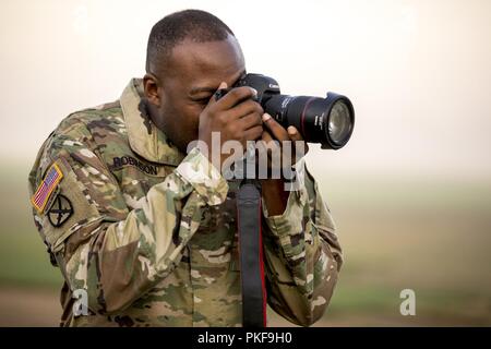 Stati Uniti Il personale dell'esercito Sgt. Ronquel Robinson, dal combattimento 982nd fotocamera Company (Airborne) documenti Leapfest 2018 presso l'Università di Rhode Island a ovest di Kingston, R.I., e il Agosto 5, 2018. Leapfest è il più grande e il più lungo in piedi, international static line parachute evento di formazione e competizione ospitata dalla 56th squadrone comando, Rhode Island Esercito Nazionale Guardia a promuovere tecniche di alto livello e formazione esprit de corps entro il International Airborne comunità. Oltre 300 i paracadutisti da nove diversi paesi potranno partecipare quest'anno. Foto Stock