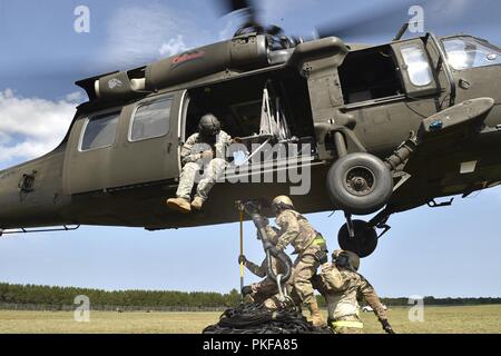 La risposta di emergenza aviatori assegnati alla contingenza 621st ala risposta da Travis Air Force Base in California, fissare un vano di carico di un UH-60 Blackhawk elicottero durante l'esercizio sciopero del Nord a Alpena Combat Readiness Training Center, Mich il Agosto 8. Sciopero del Nord è una solida preparazione militare esercizio coordinato dall'esercito del Michigan Guardia Nazionale quali funzioni congiunte e multi-nazionale le forze armate di lavorare insieme per la forza totale integrazione. Foto Stock