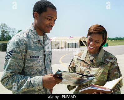Stati Uniti Air Force Staff Sgt. Xavier Lockley, 927th Air Refuelling Wing, MacDill AFB, Fla., e DEGLI STATI UNITI Esercito Col. Angela Garner, Medico Readiness comando di formazione di base comune San Antonio, TX., si prepara per un colloquio per discutere il suo ruolo come vice direttore di esercizio per Global Medic nonché l'integrazione del patriota Warrior a Fort McCoy, Wis., il 10 agosto 2018. Patriot Warrior è aria riserva di forza di comando esercizio premier, fornendo un'opportunità per il cittadino di riserva aviatori di allenarsi con giunto e i partner internazionali in airlift, Istituto di medicina aeronautica evacuazione e il supporto della mobilità. Foto Stock