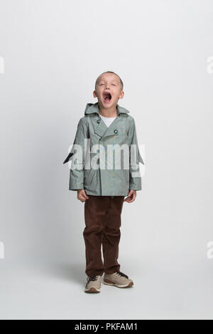 Urlando little boy su sfondo bianco, riprese in studio Foto Stock