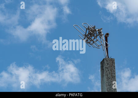 Rotture di alluminio antenna TV su un palo in cemento con le nuvole e il cielo Foto Stock