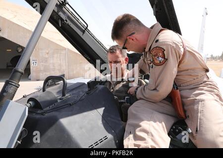 Stati Uniti Air Force Il Mag. Gen. Ciad P. Franchi, Combined Joint Task Force - Funzionamento inerenti risolvere vice Comandante per le operazioni e intelligenza e Comandante del IX Air Expeditionary Task Force, è fissato nel cockpit di iracheni e F-16 al Balad Air Base, Iraq, il 6 agosto 2018. Consigliare e assistere i team sono consentendo una partnership le forze per sconfiggere ISIS fornendo corsi di formazione e di orientamento con militare la pianificazione operativa, manovra, intelligenza e il supporto aereo sul campo di battaglia. Foto Stock