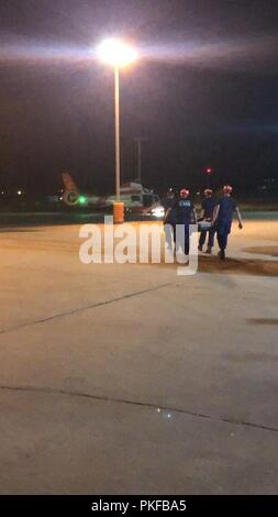 Coast Guard i deputati alla stazione Freeport, Texas trasportare un uomo verso un MH-65 Delfino elicottero equipaggio Agosto 12, 2018. L'uomo è stato riferito che soffrono di sequestro di sintomi simili ed è stato trasferito fuori il suo peschereccio da una stazione Freeport 45-piede Boat-Medium risposta equipaggio. Foto Stock