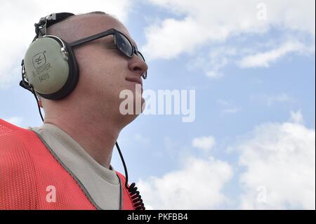 Il personale Sgt. Benjamin Stover, 821st risposta di emergenza squadrone di supporto capo equipaggio, esegue il marshalling di un C-130H Hercules aeromobili, durante l'esercizio sciopero del Nord a temoli Army Airfield, Mich il Agosto 9. Sciopero del Nord è una solida preparazione militare esercizio coordinato dall'esercito del Michigan Guardia Nazionale quali funzioni congiunte e multi-nazionale le forze armate di lavorare insieme per la forza totale integrazione. Foto Stock